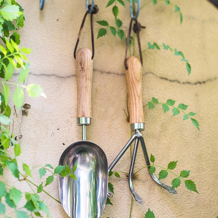 Rustic style pruning shears and gardening tools with wooden handles and stainless steel blades, arranged on a wooden surface.