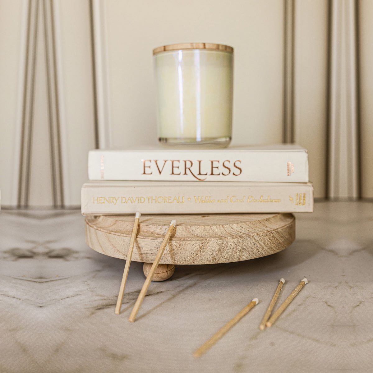 A rustic wooden stand with three legs, showcasing a distressed white finish, perfect for home decor.