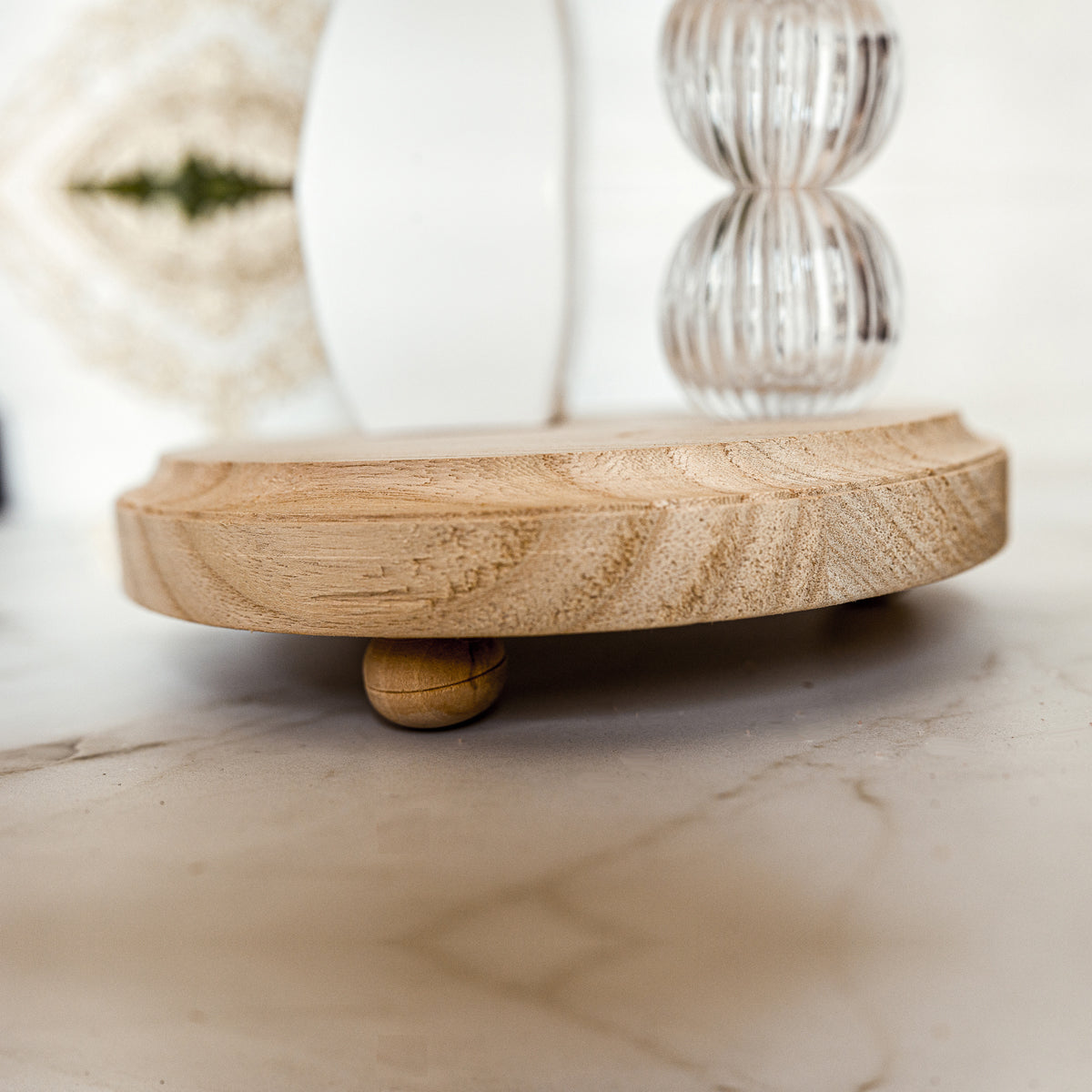 A rustic wooden stand with three legs, showcasing a distressed white finish, perfect for home decor.