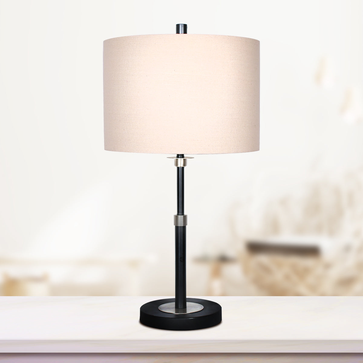 Sarantino Metal Table Lamp with a cream linen drum shade and black metal base, showcasing a modern and elegant design.