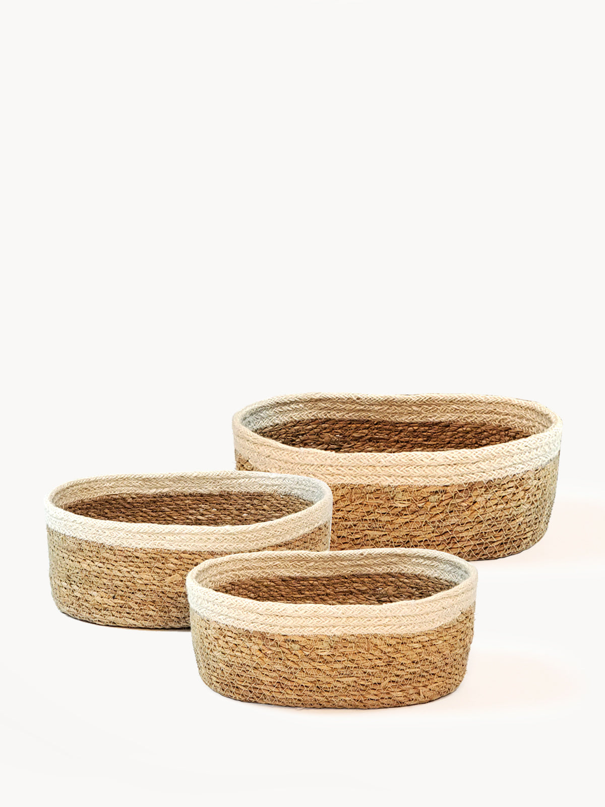 Set of 3 Savar Oval Bowls made from seagrass and jute, showcasing their natural and white colors.