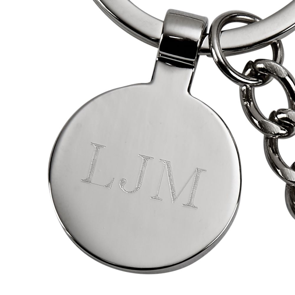 A polished nickelplated saw keychain with an engraving tag, elegantly displayed in a black gift box.