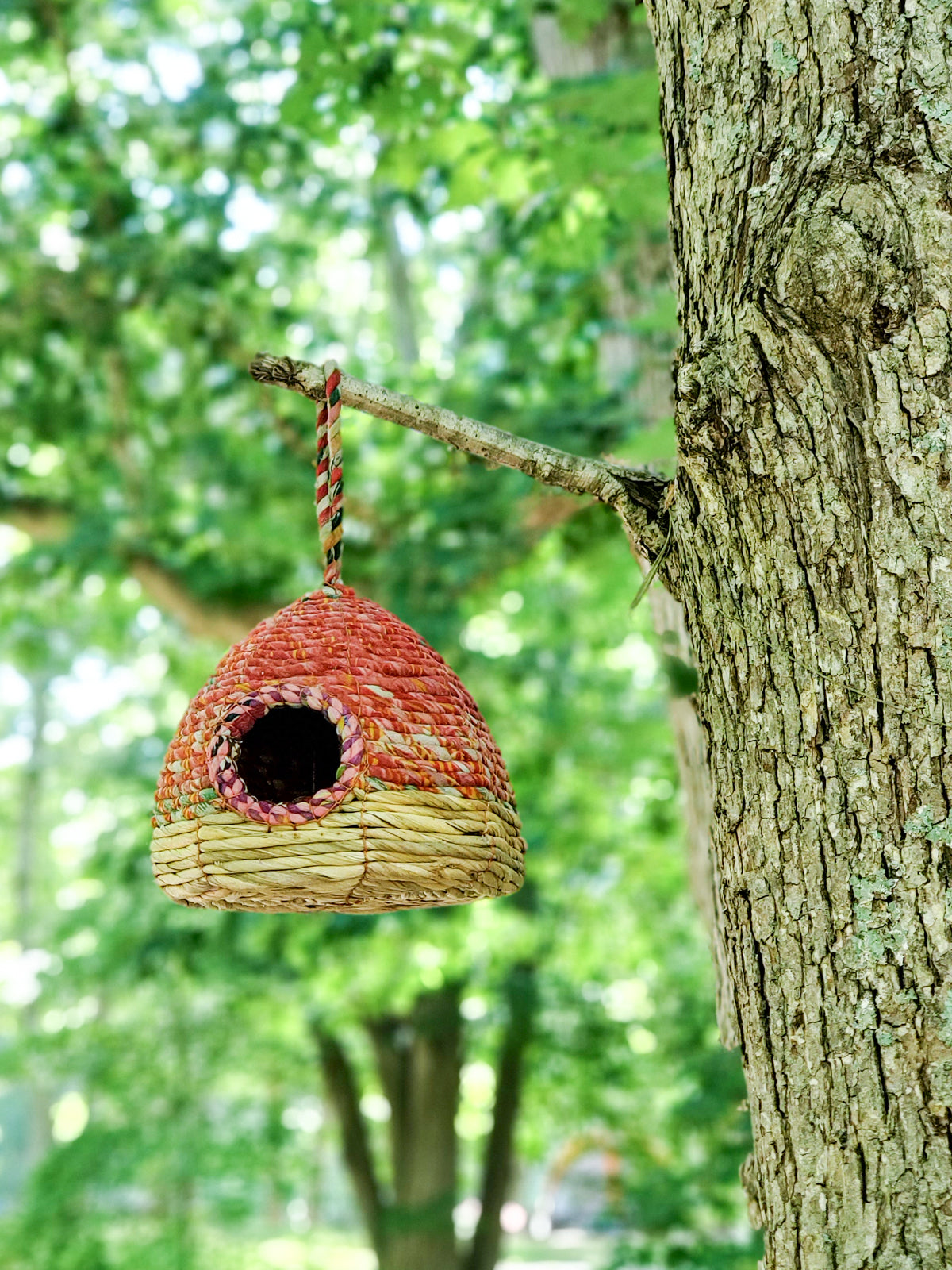 Handcrafted Seagrass & Sari Birdhouse featuring vibrant sari fabrics and natural seagrass, perfect for garden decor.