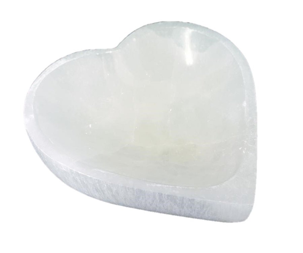 A beautifully hand-carved Selenite Heart Bowl, showcasing its unique shape and natural imperfections, perfect for crystal cleansing or decorative use.