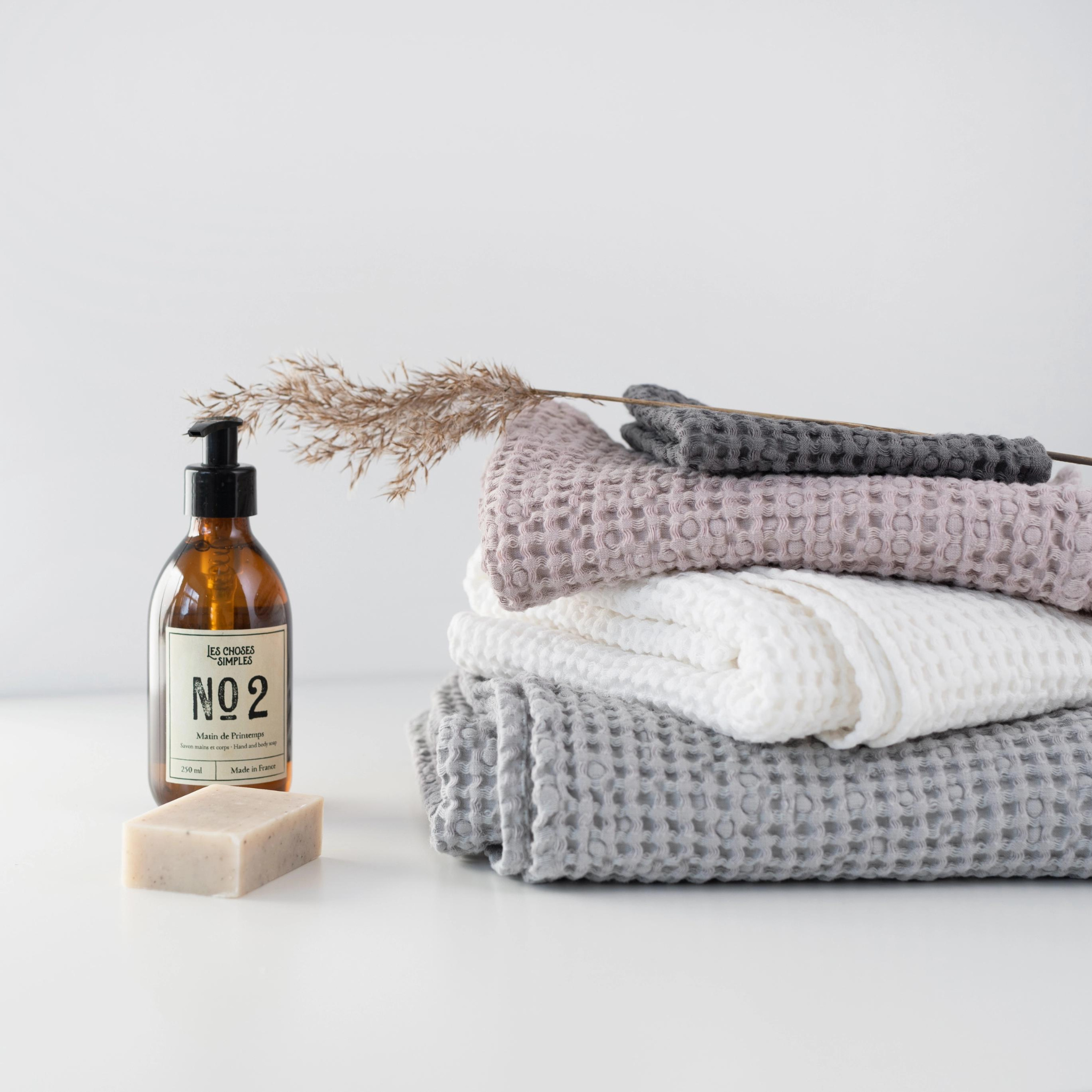 Set of three crispy white waffle linen towels in various sizes, showcasing their soft texture and absorbent quality.