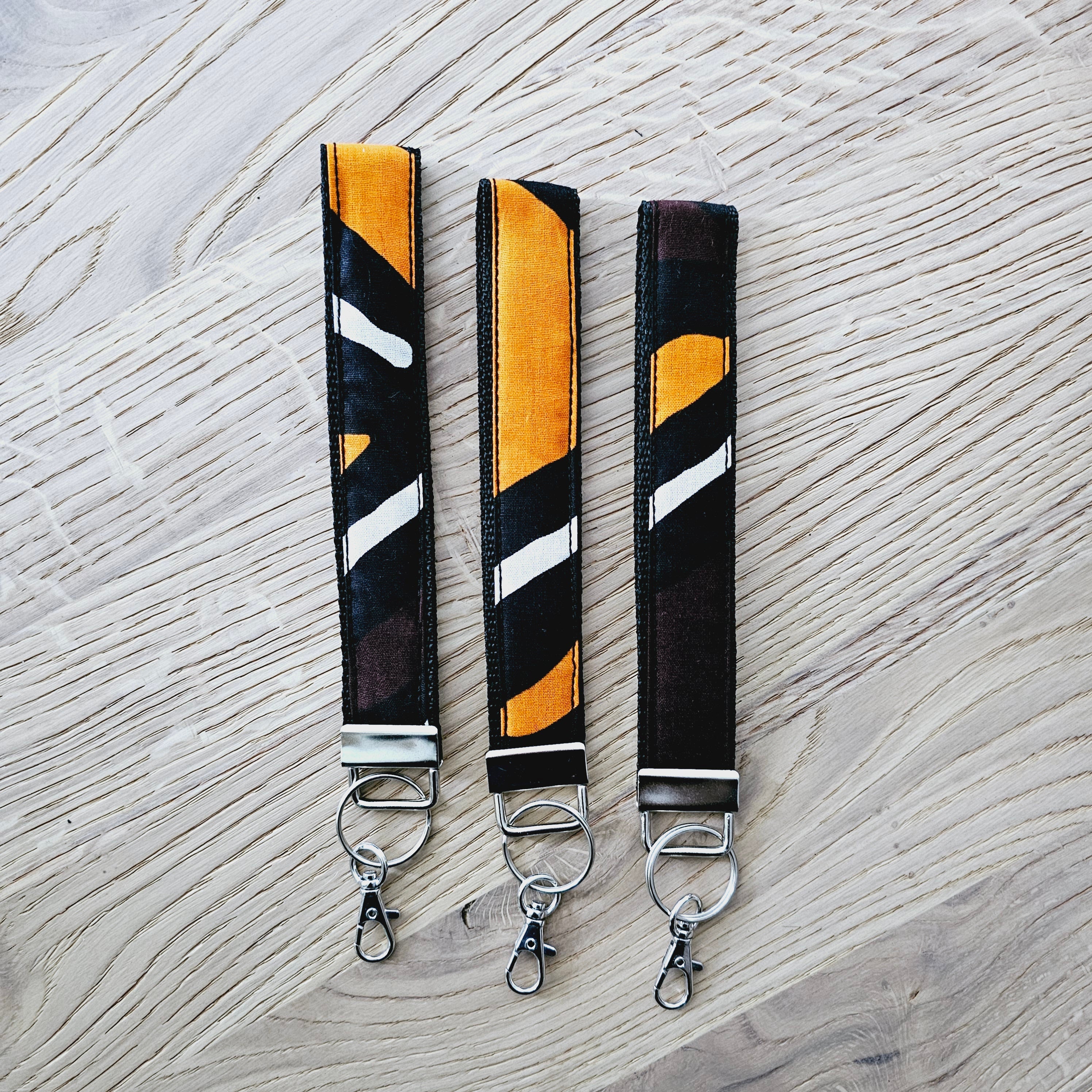 Set of 3 vibrant African print key fobs with wristlet design, showcasing unique patterns and vegan leather lining.