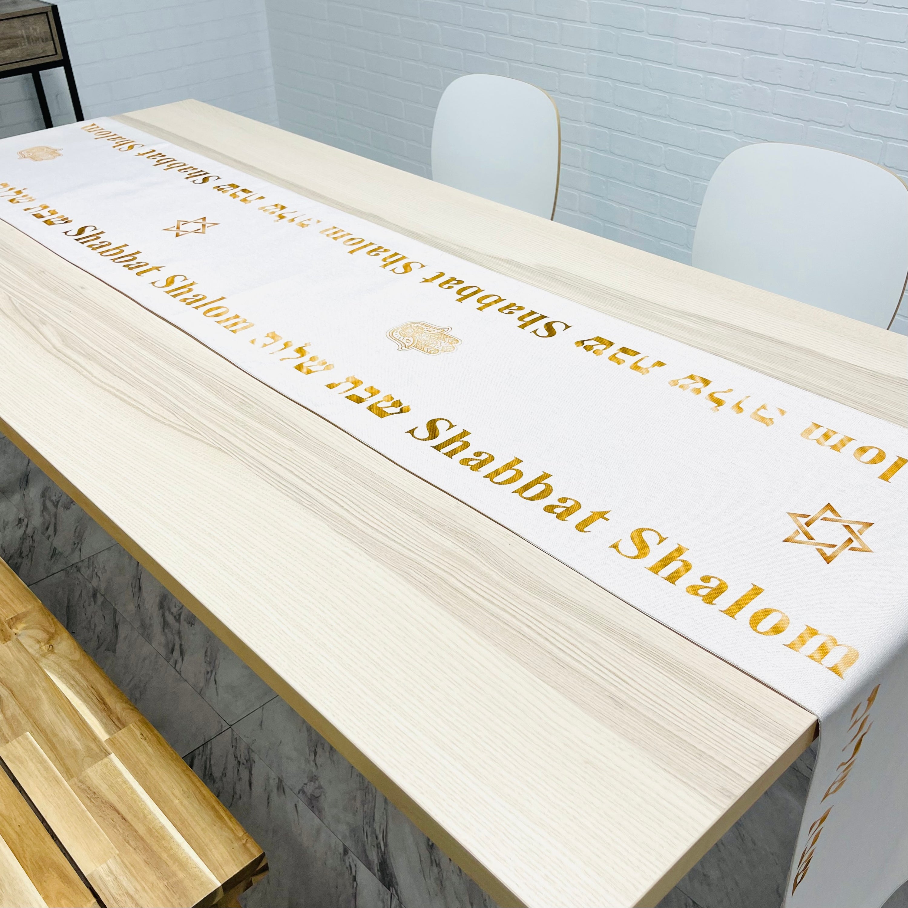 Elegant cream-colored Shabbat Shalom table runner featuring Stars of David and Hamsa symbols, perfect for festive dining.