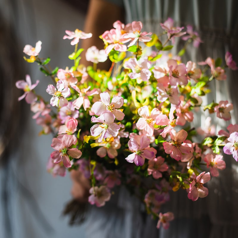 A 20-inch tall Silk Faux Gaura Flower Stem in pink, featuring realistic petals and dark green leaves, perfect for home decor.