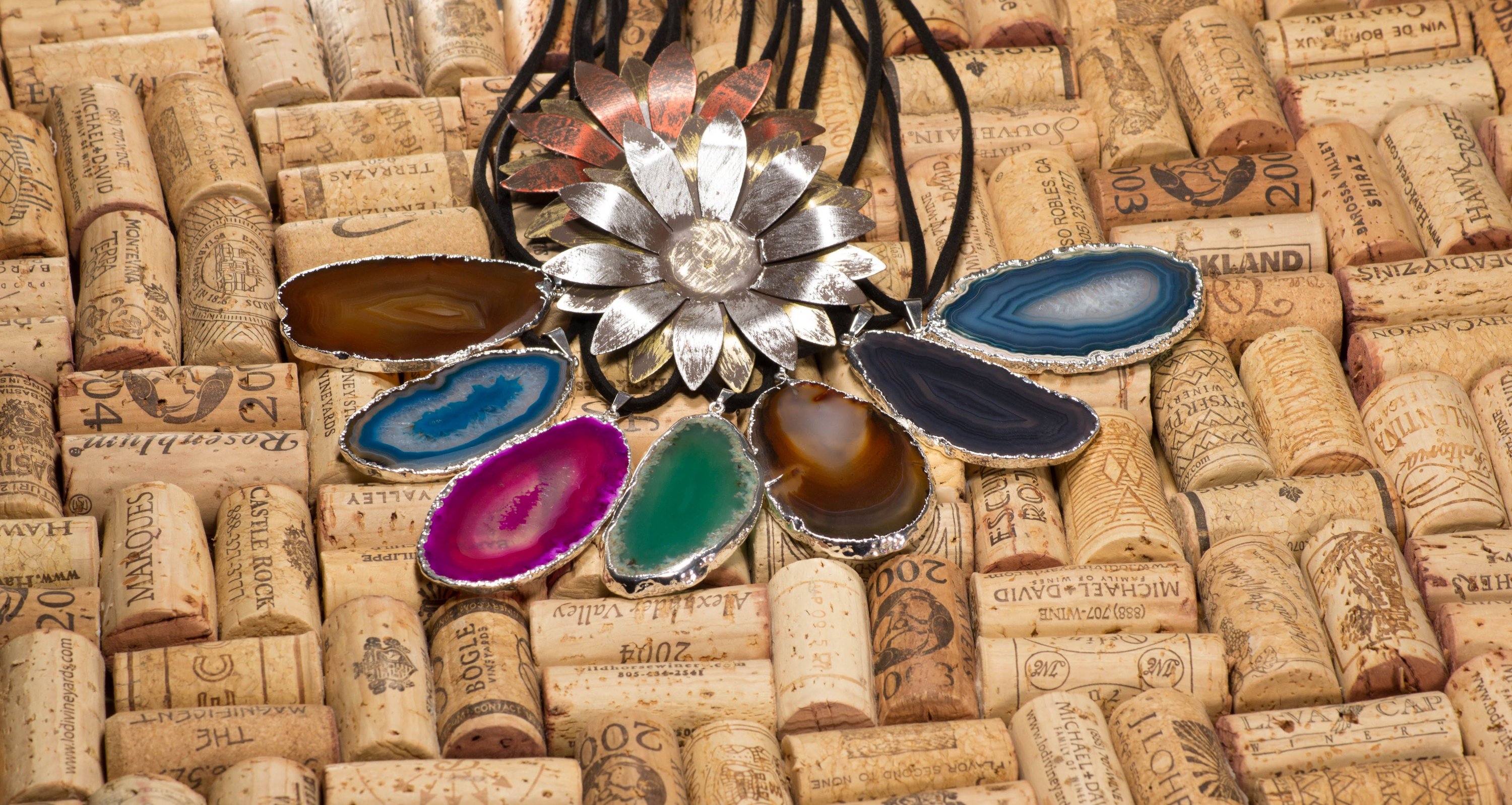 A stylish silver electroplated agate slice pendant hanging from a leather cord, showcasing vibrant colors and unique patterns.