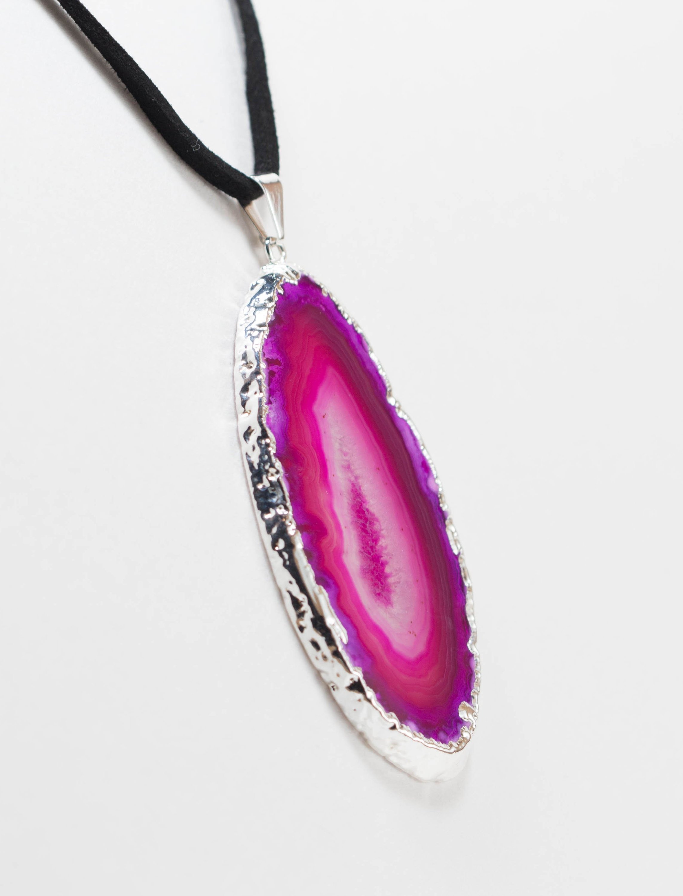 A stylish silver electroplated agate slice pendant hanging from a leather cord, showcasing vibrant colors and unique patterns.