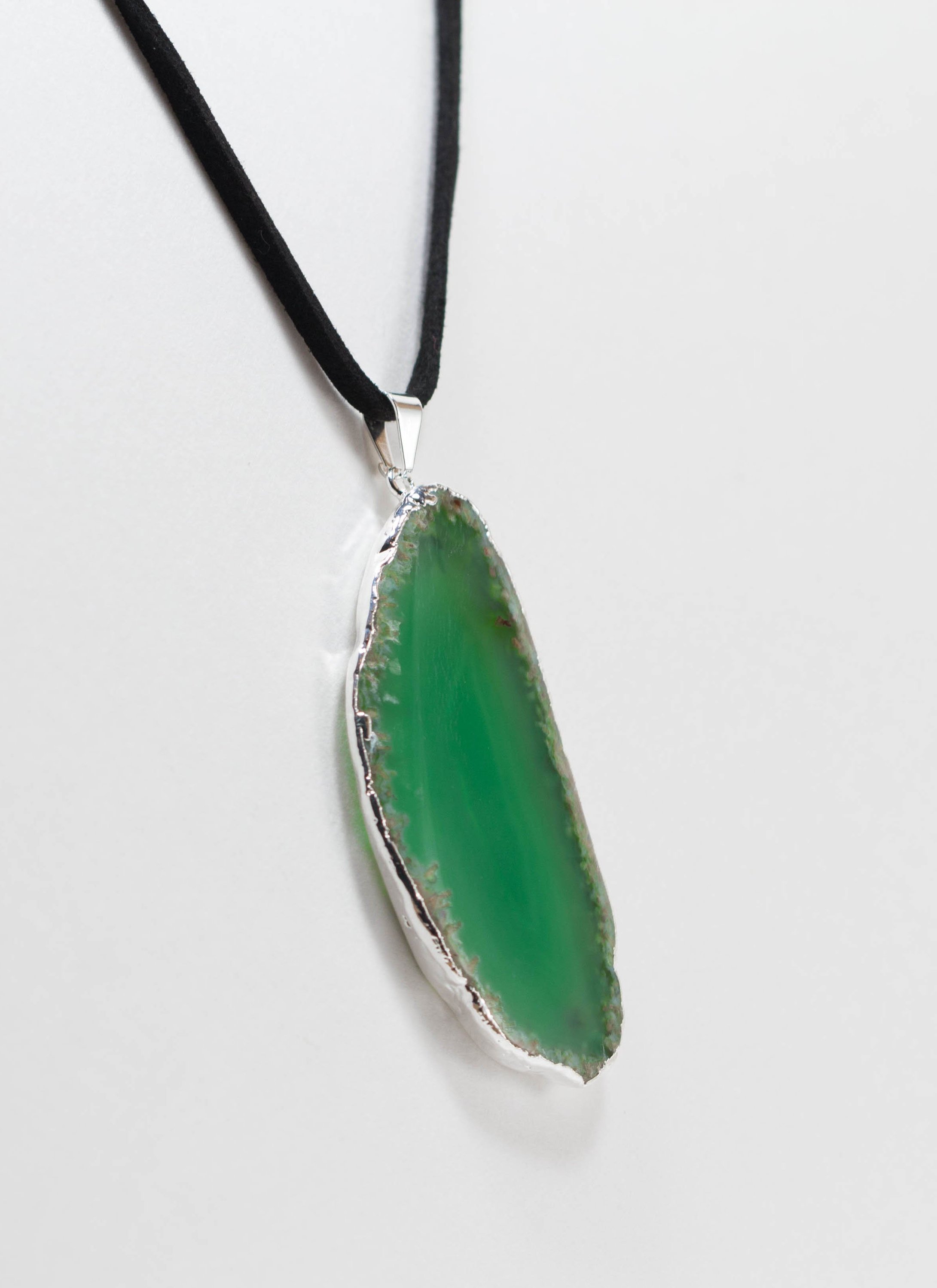 A stylish silver electroplated agate slice pendant hanging from a leather cord, showcasing vibrant colors and unique patterns.