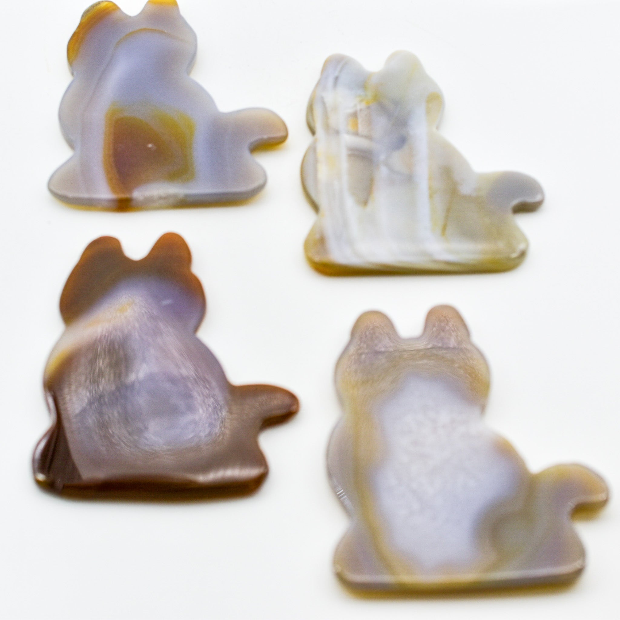 A polished agate stone shaped like a sitting cat, showcasing unique patterns and colors.