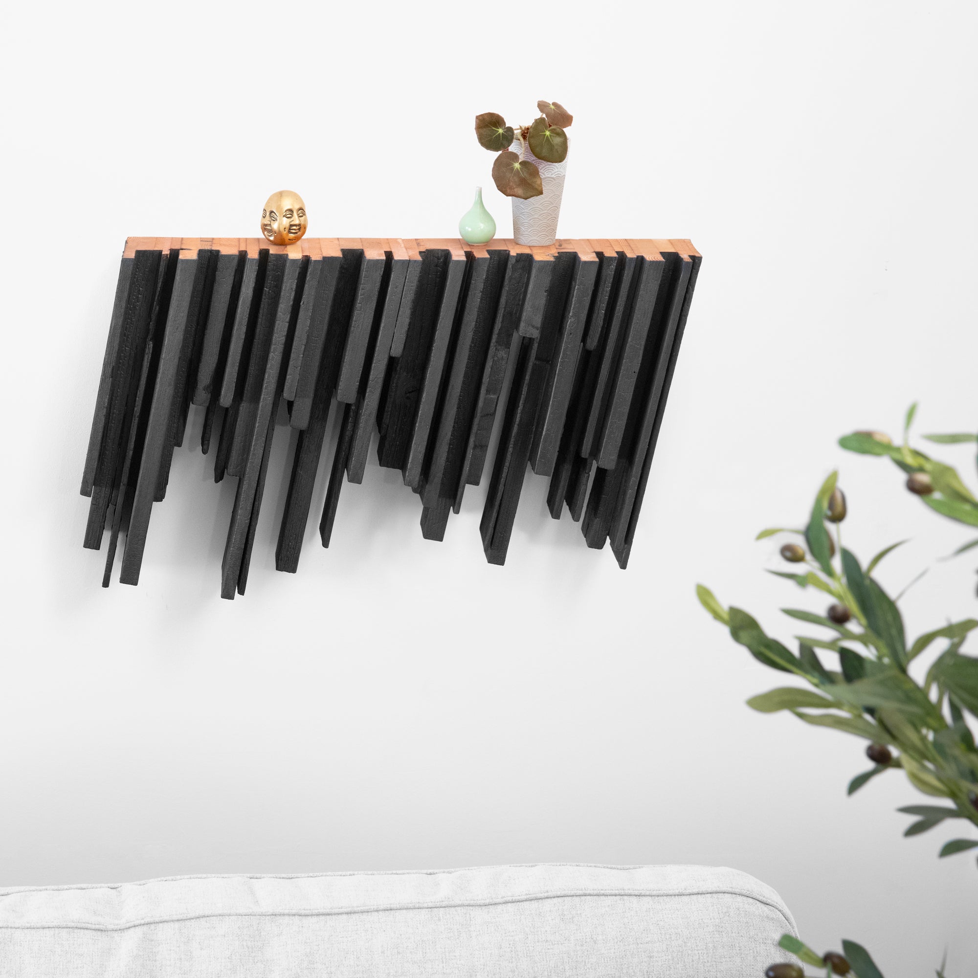 Skyline shelf made from recycled wood with a dynamic inverted design, showcasing torched black and natural finishes.