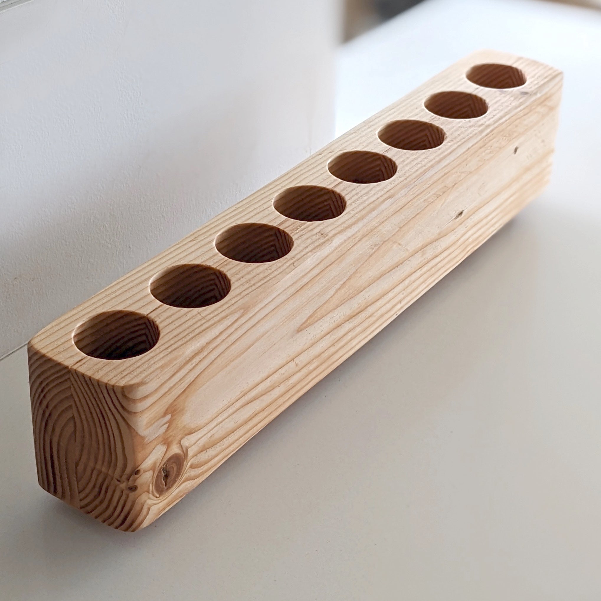 Slot cooking utensil holder made from Doug Fir wood, featuring a narrow design to save counter space and store up to eight utensils.