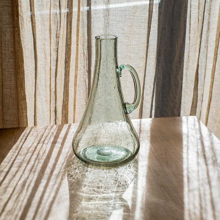 A 13-inch tall bubble glass kettle vase with a small opening, featuring a clear and light green color, perfect for floral arrangements.