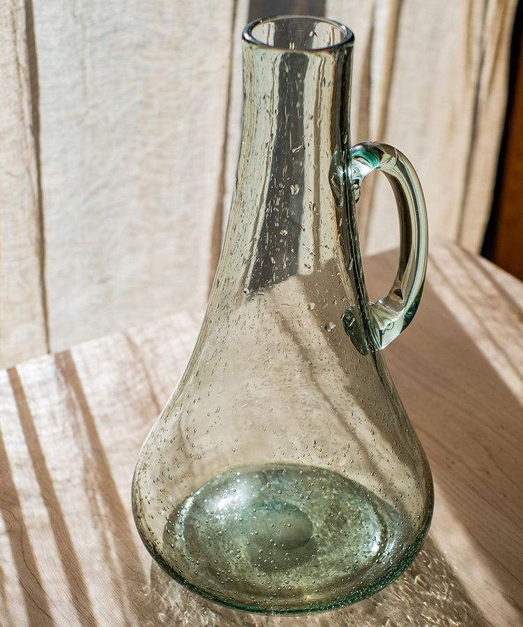 A 13-inch tall bubble glass kettle vase with a small opening, featuring a clear and light green color, perfect for floral arrangements.