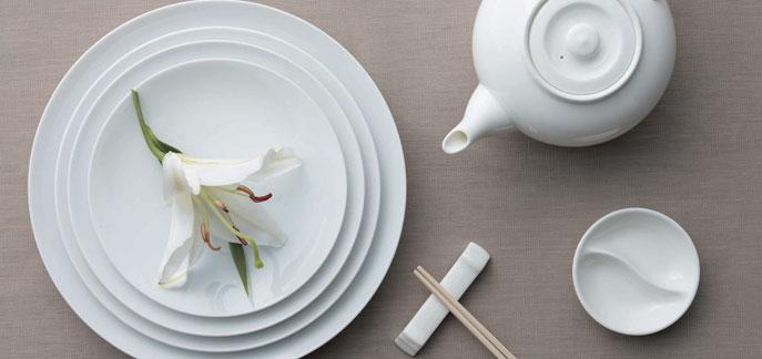 A sleek small white porcelain chopstick rest with a circular design, ideal for holding chopsticks and utensils securely.