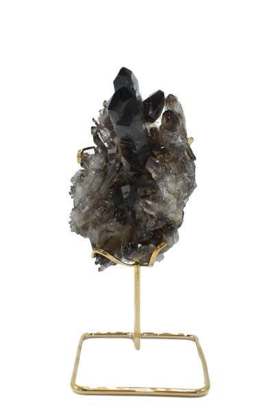 A beautiful smoky quartz cluster displayed on a gold wire stand, showcasing its natural formations and colors.