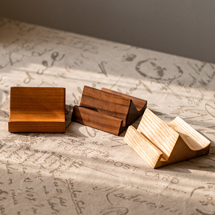 A handcrafted solid wood cellphone stand made from white ash, cherry, or walnut, showcasing its unique design and natural finish.