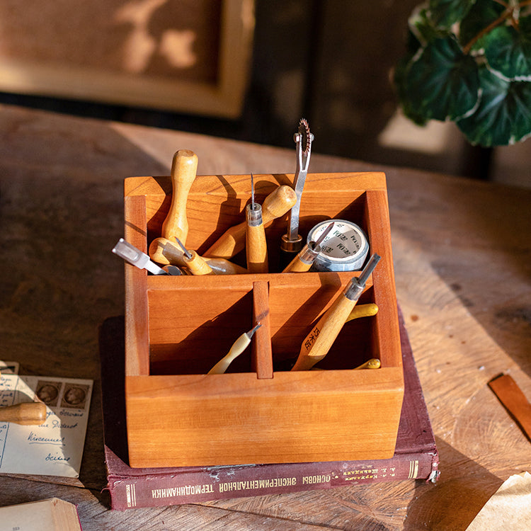 A handcrafted solid wood desktop organizer in natural brown, featuring compartments for pens and small office supplies.