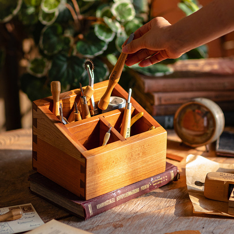 A handcrafted solid wood desktop organizer in natural brown, featuring compartments for pens and small office supplies.