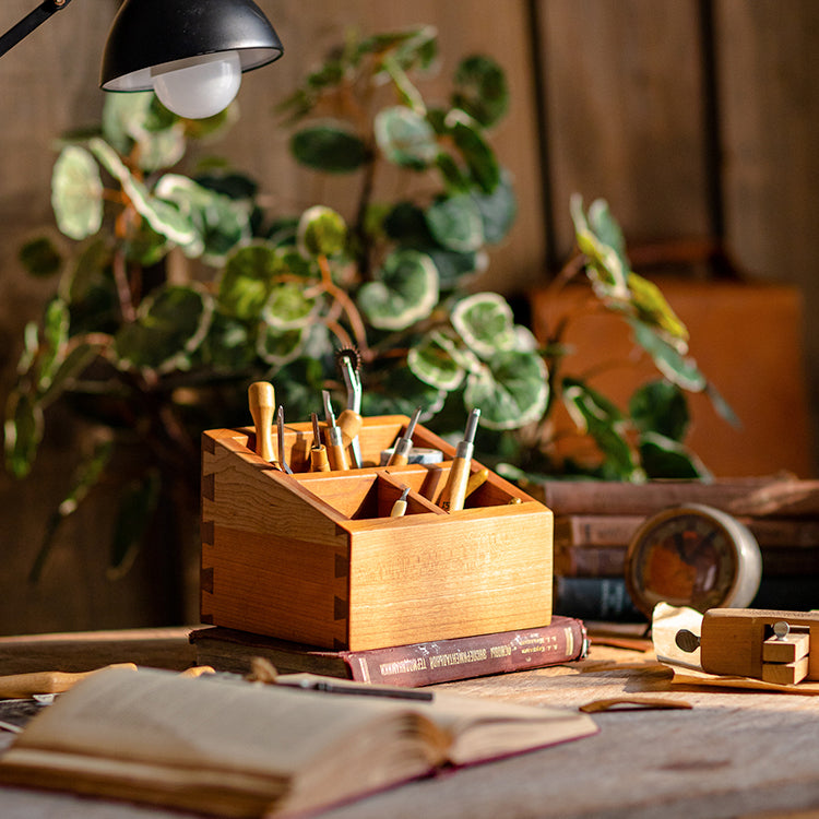 A handcrafted solid wood desktop organizer in natural brown, featuring compartments for pens and small office supplies.