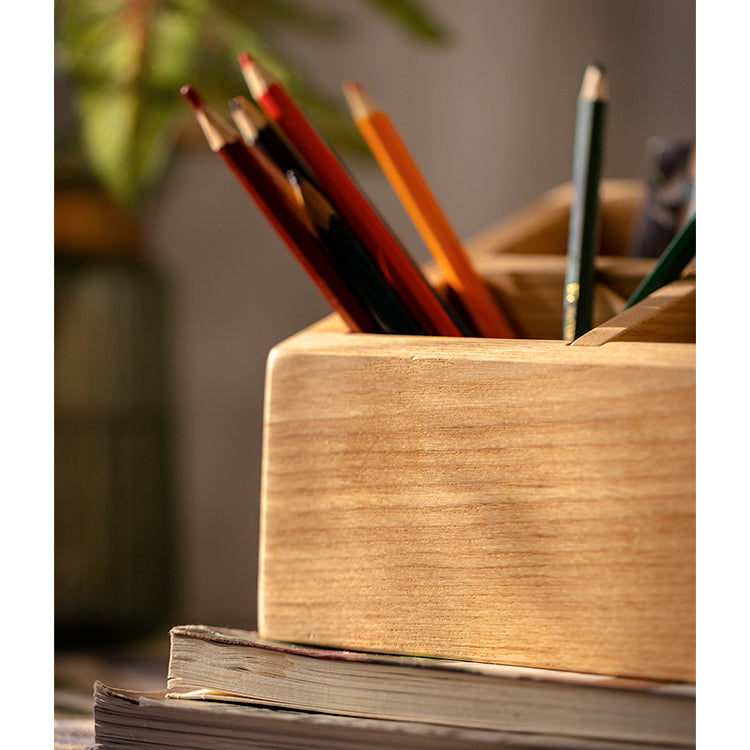 A handcrafted solid wood desktop organizer in natural brown, featuring compartments for pens and small office supplies.