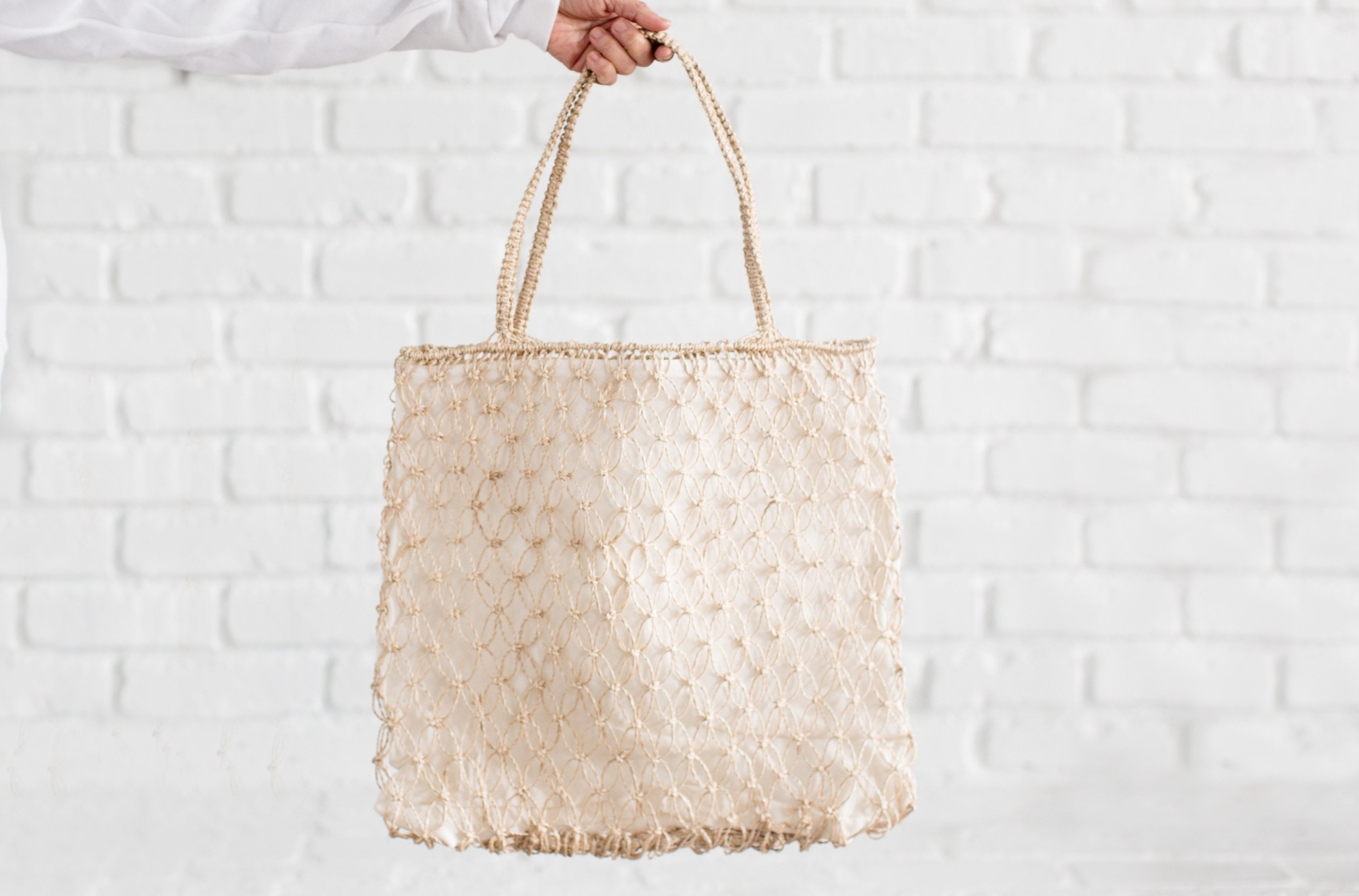 A beautifully handwoven Sphere Jute Tote bag featuring a bold woven pattern, perfect for beach outings and casual wear.