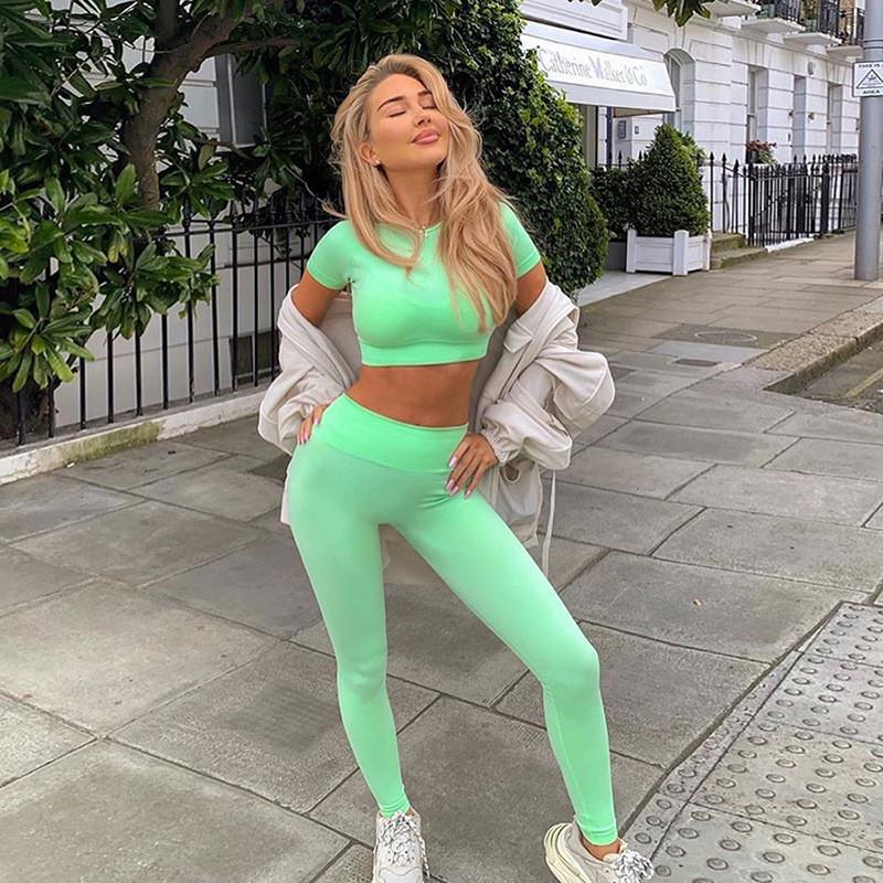 Sporty women's tracksuit featuring a solid short sleeve crop top and high-waisted leggings in vibrant colors, perfect for casual and active wear.