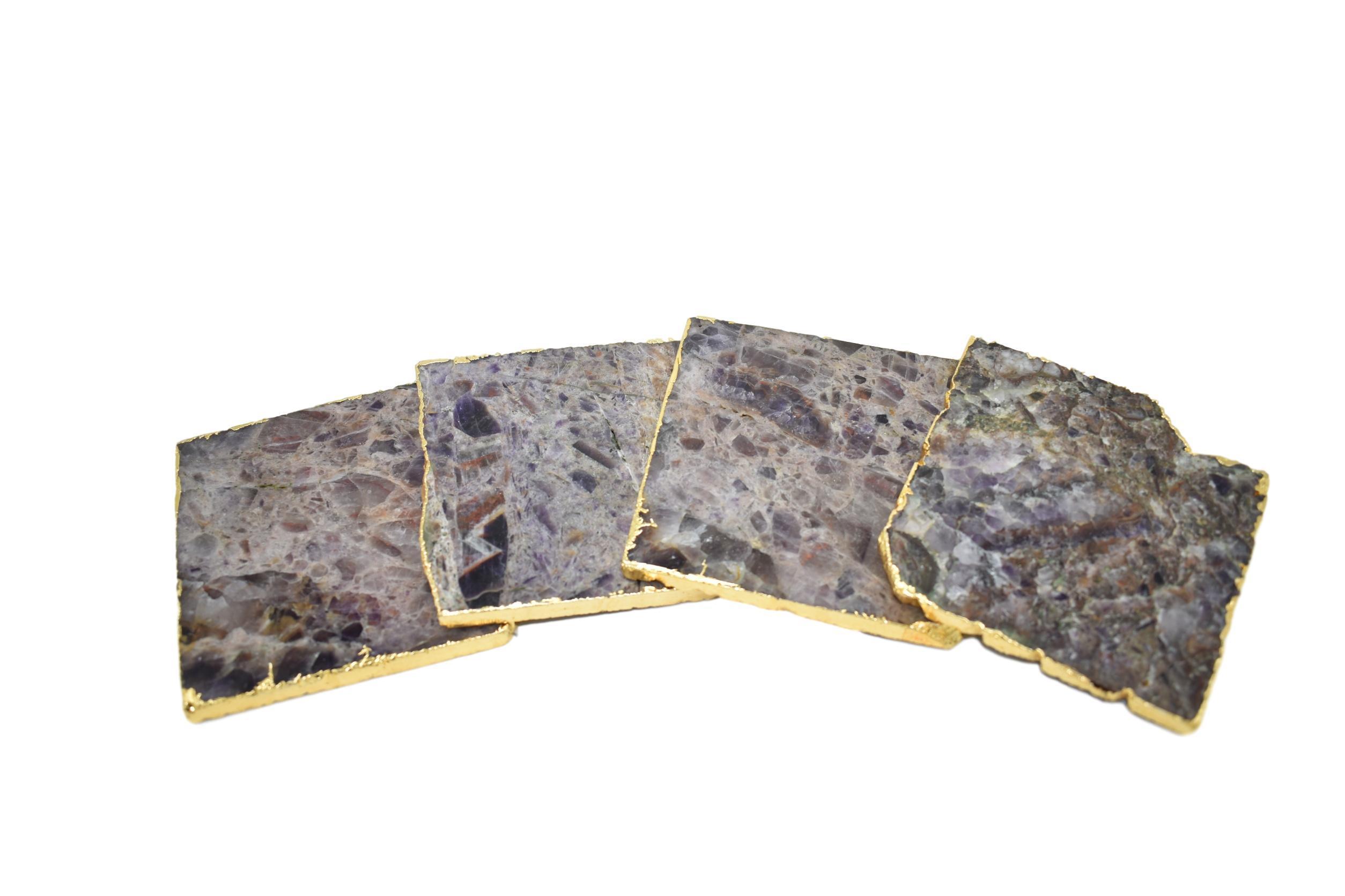 Set of four square coasters with gold trim, featuring amethyst, rose quartz, and clear quartz designs, elegantly protecting tabletops.