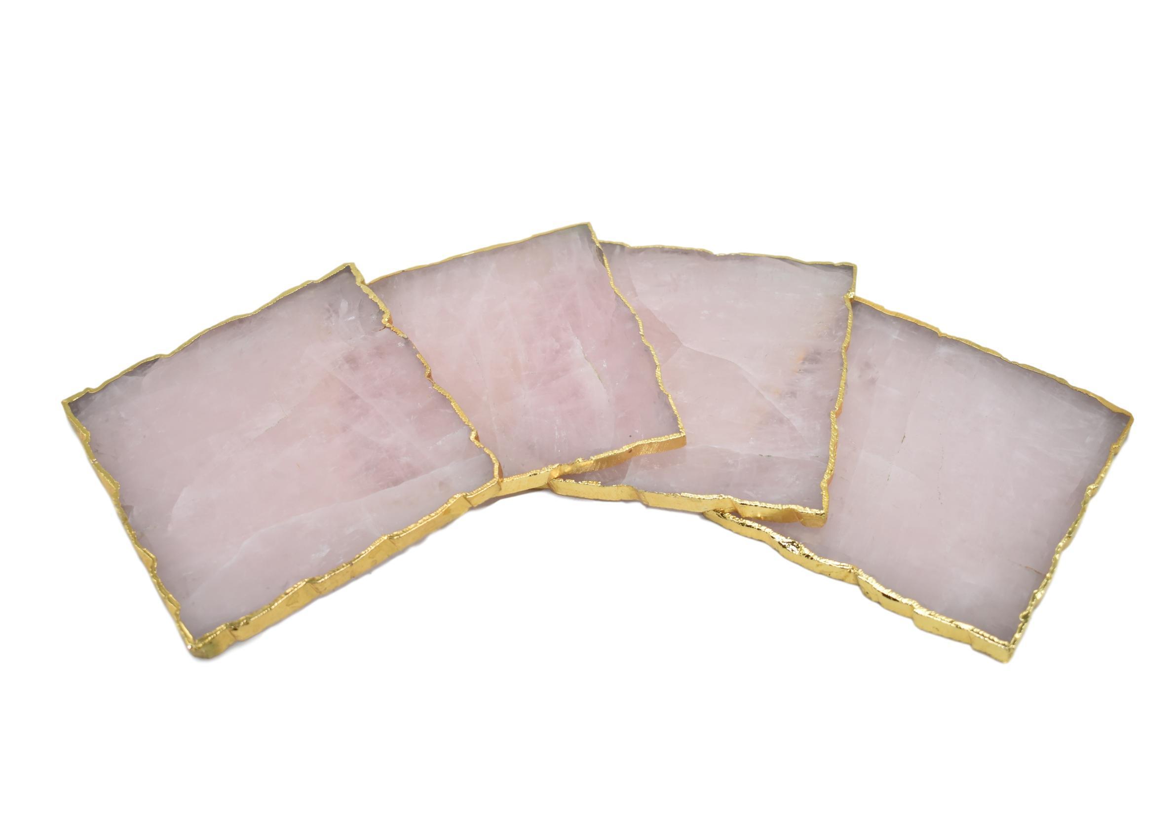 Set of four square coasters with gold trim, featuring amethyst, rose quartz, and clear quartz designs, elegantly protecting tabletops.