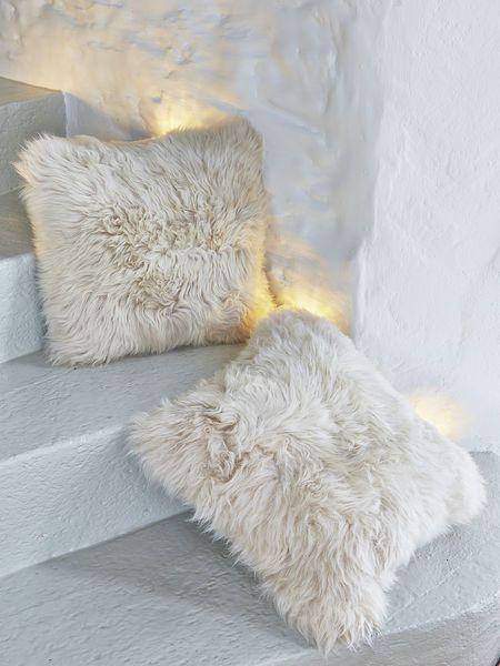 A luxurious square furry pillow made from 100% natural sheepskin, showcasing its soft and fluffy texture in a cozy setting.