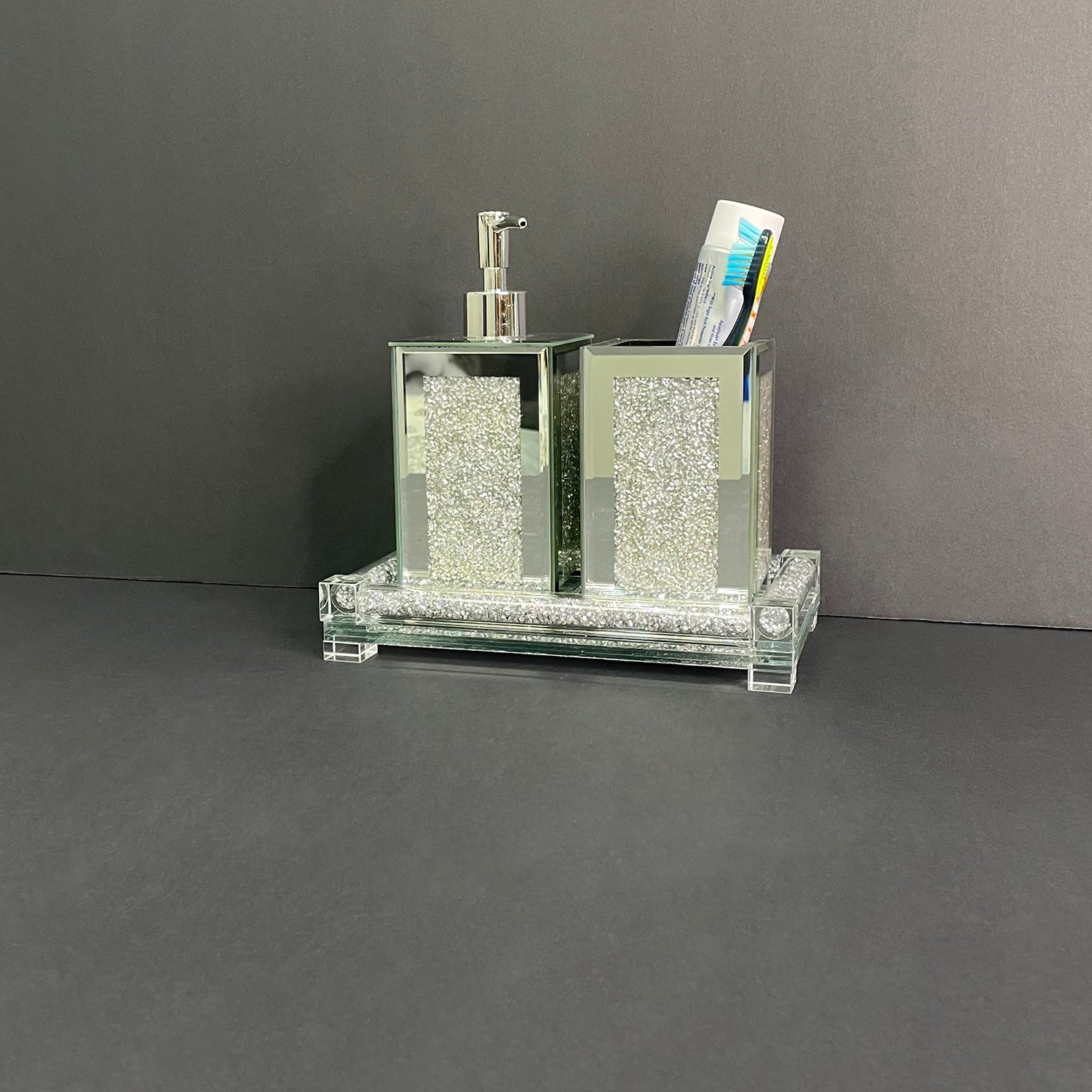 Square soap dispenser and toothbrush holder set in silver crushed diamond design, featuring chrome accents and an elegant tray.