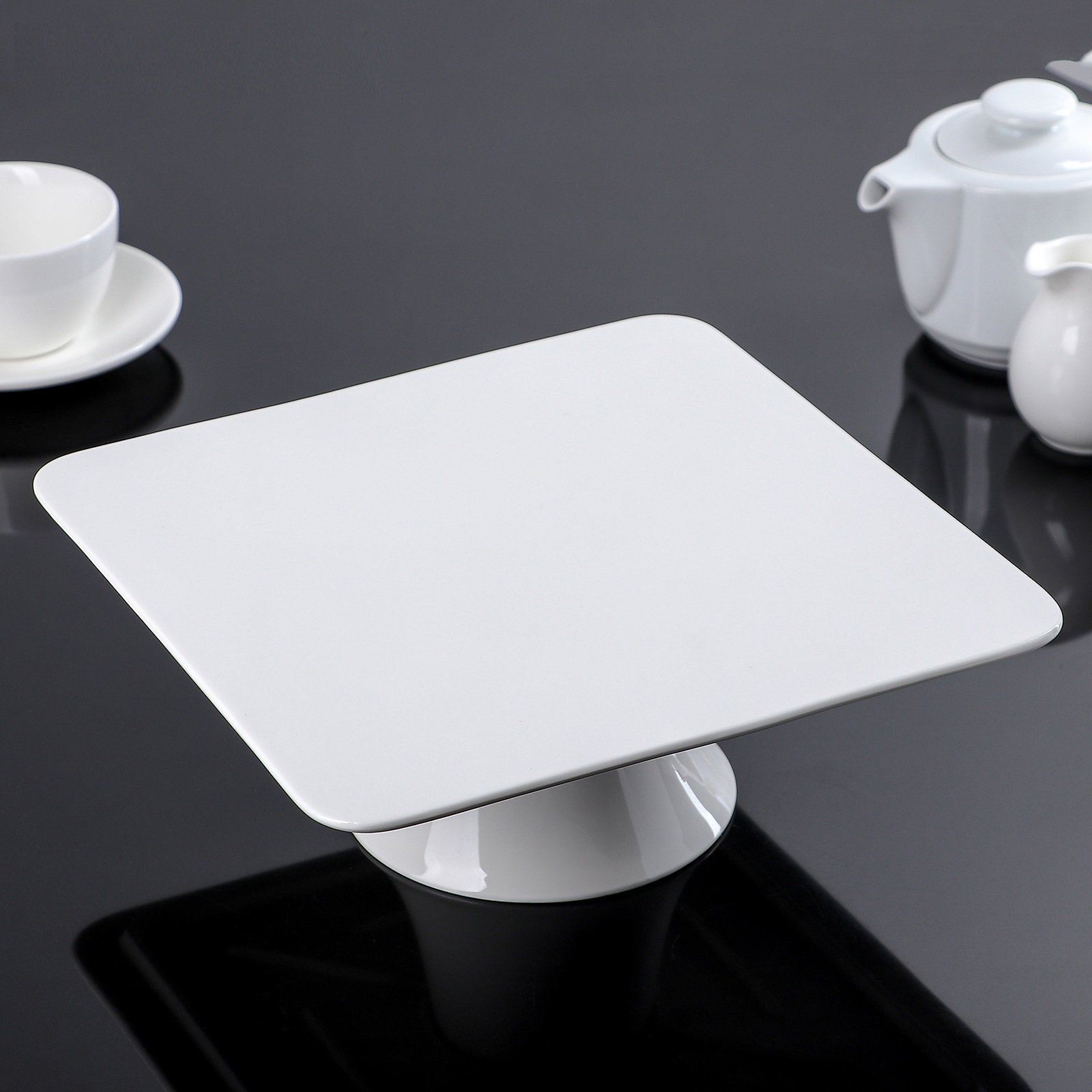 Elegant square white porcelain cake stand, 12 inches by 12 inches, perfect for displaying cakes and pastries.