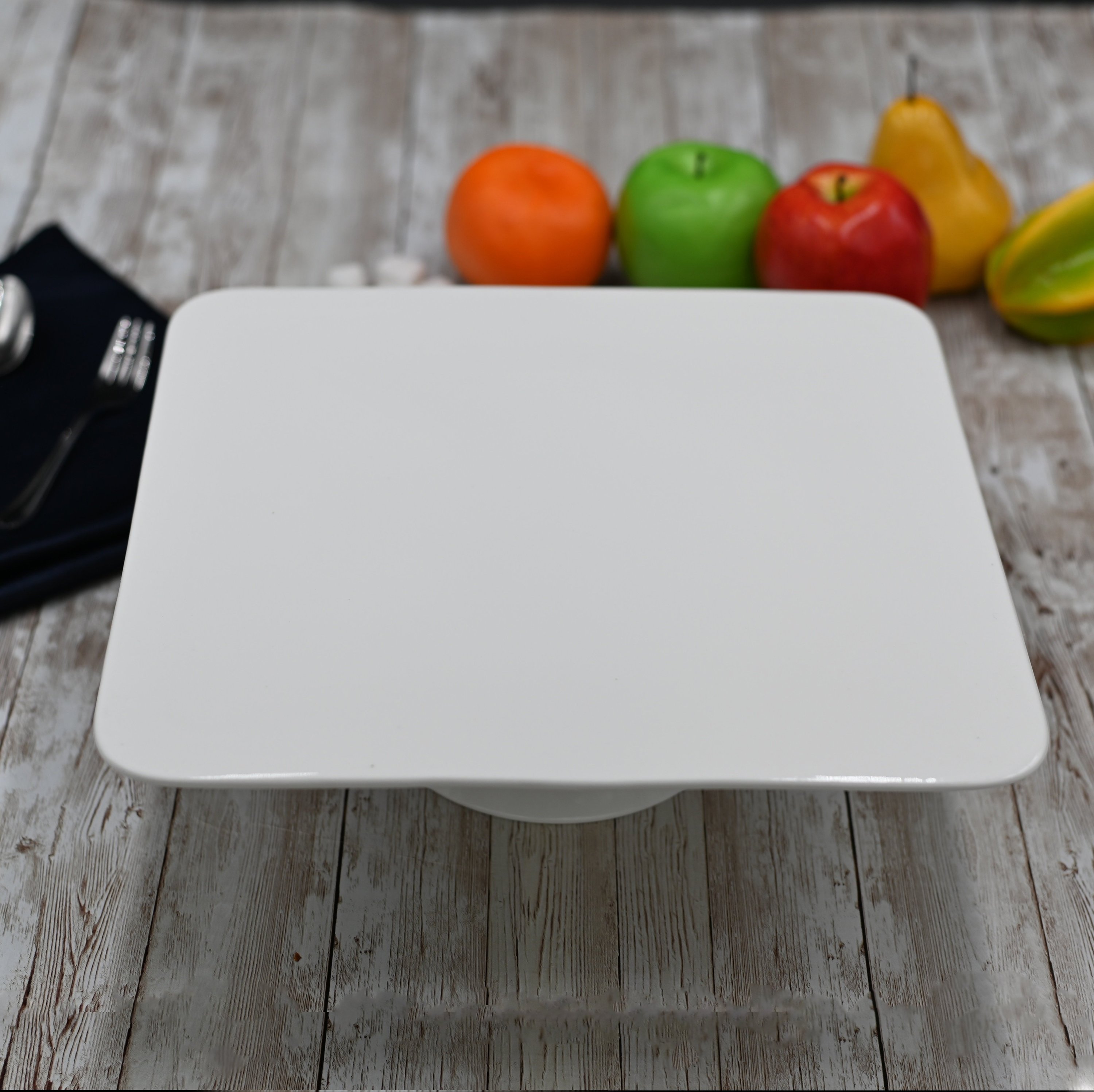 Elegant square white porcelain cake stand, 12 inches by 12 inches, perfect for displaying cakes and pastries.