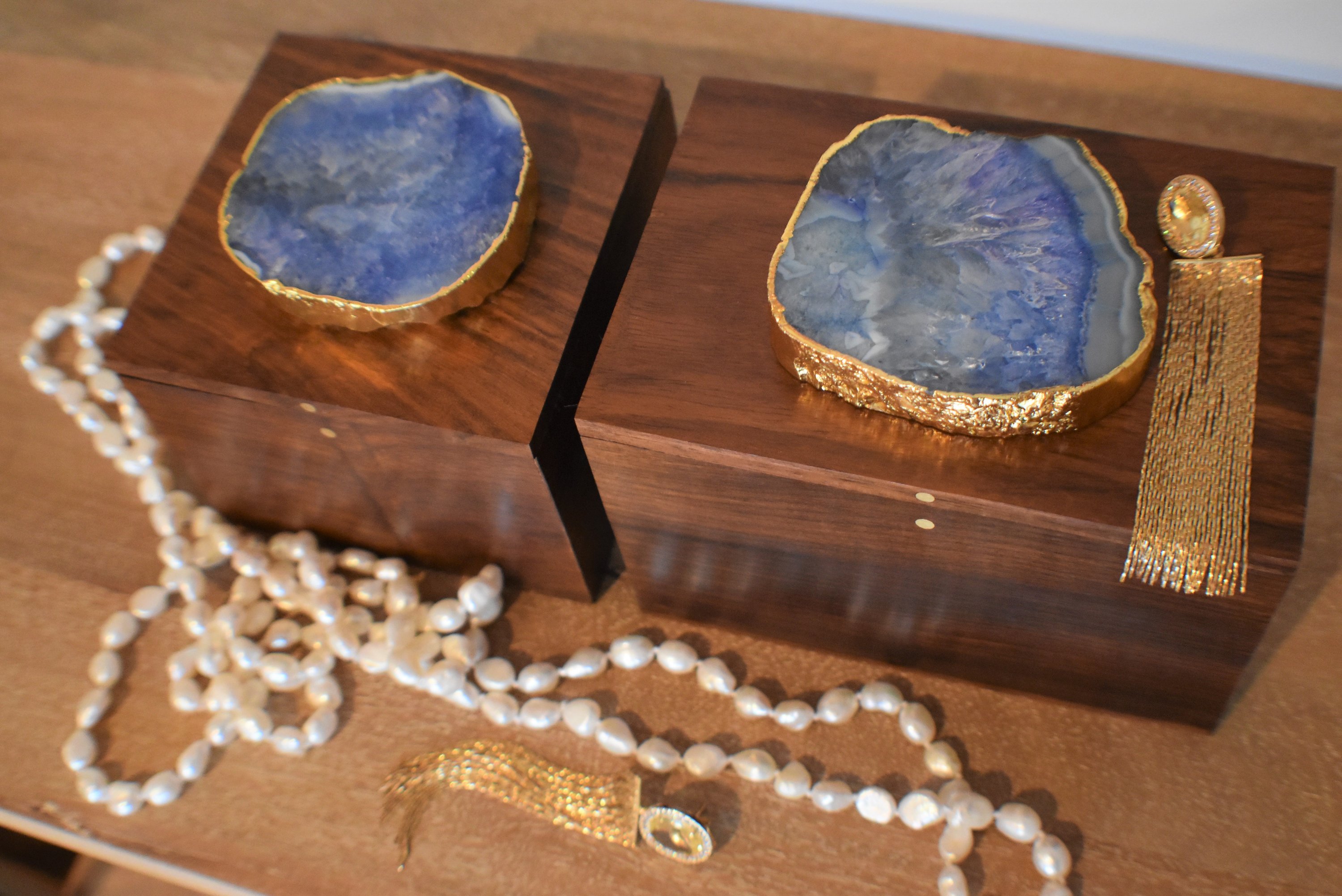 A square wooden box featuring a stunning agate top with gold trim, perfect for storing jewelry and enhancing home decor.