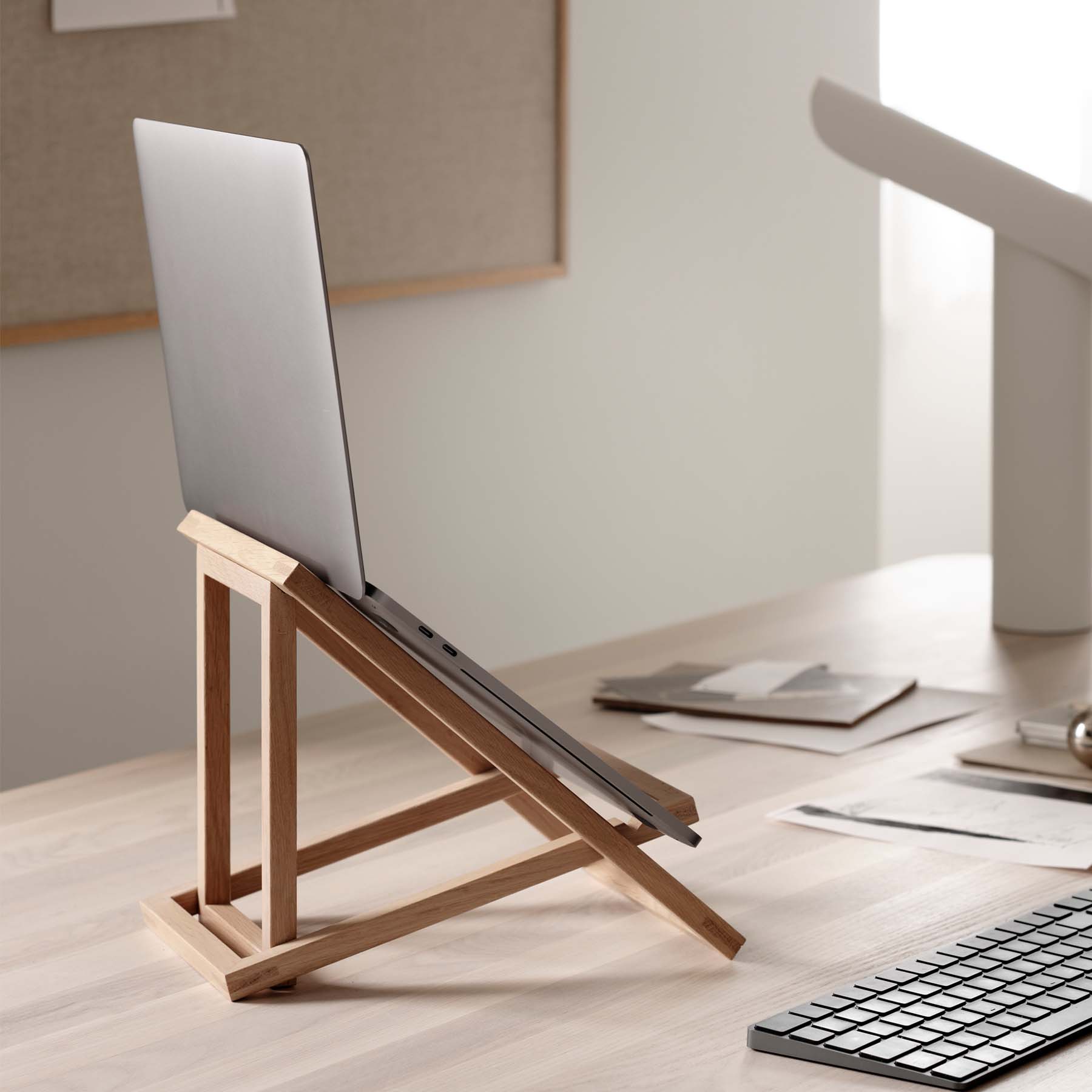 A sleek and modern foldable Standing Laptop Stand elevating a laptop for ergonomic use.