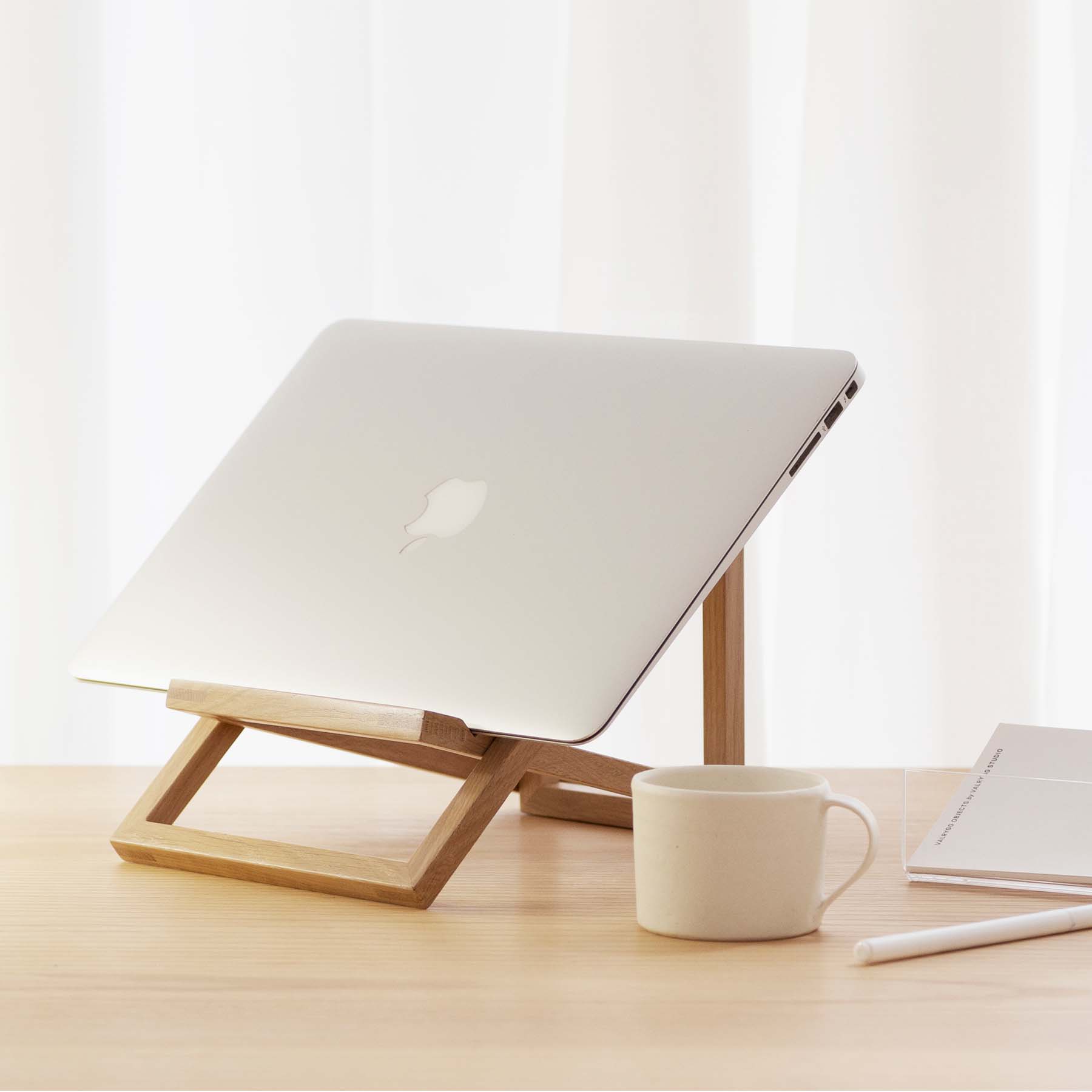 A sleek and modern foldable Standing Laptop Stand elevating a laptop for ergonomic use.