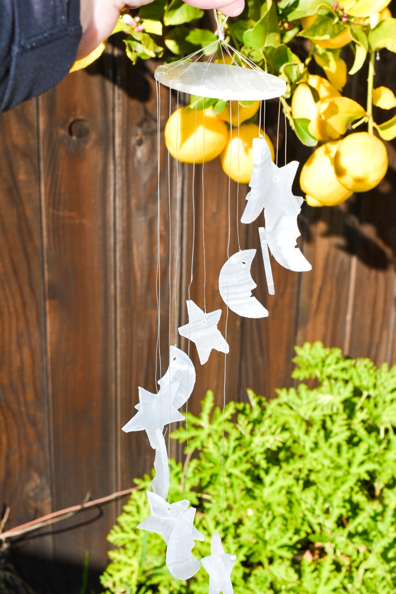 Handmade wind chime featuring stars and moons crafted from natural white onyx, promoting peace and serenity.