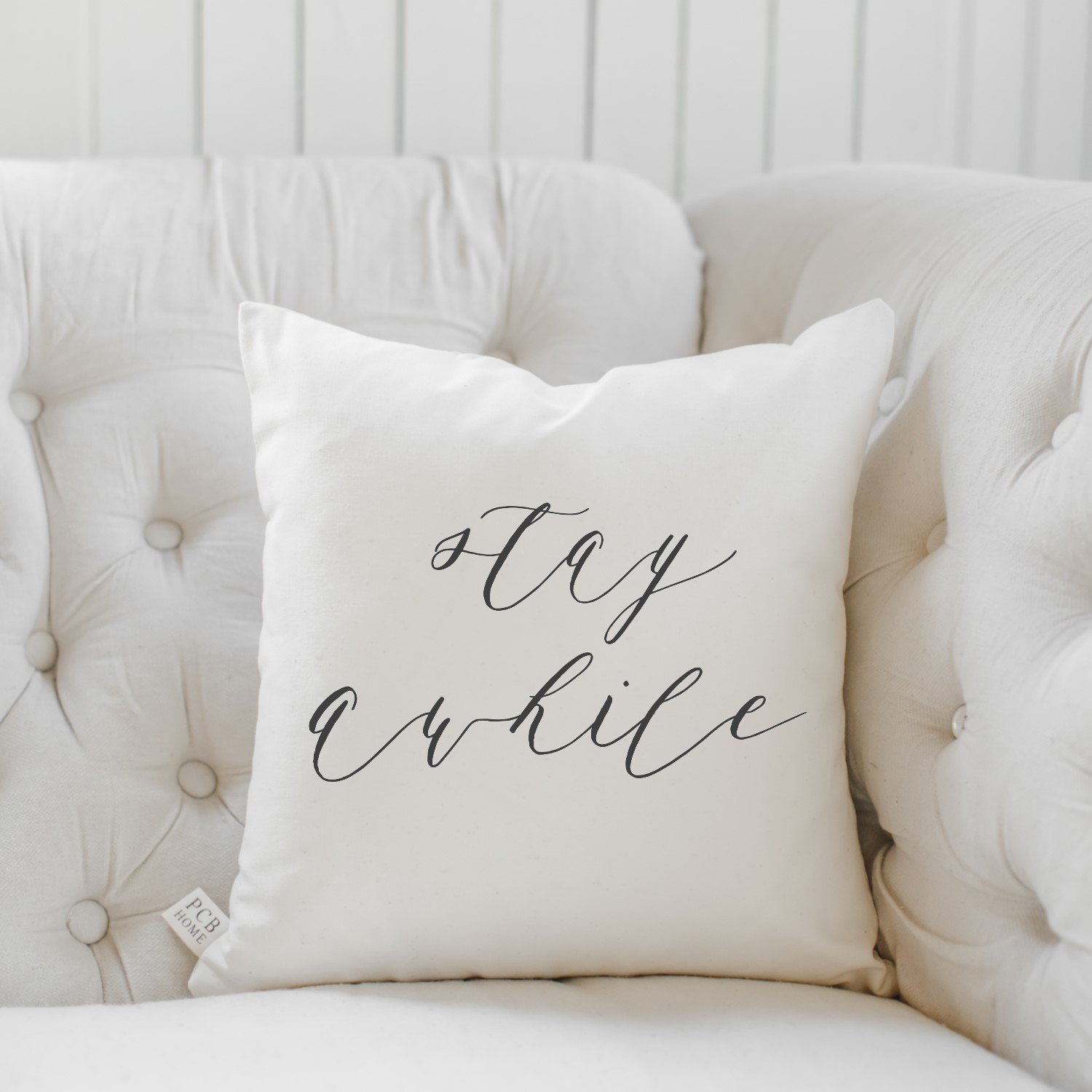 Stay Awhile Pillow featuring unique calligraphy designs, handmade from eco-friendly cotton in neutral colors.