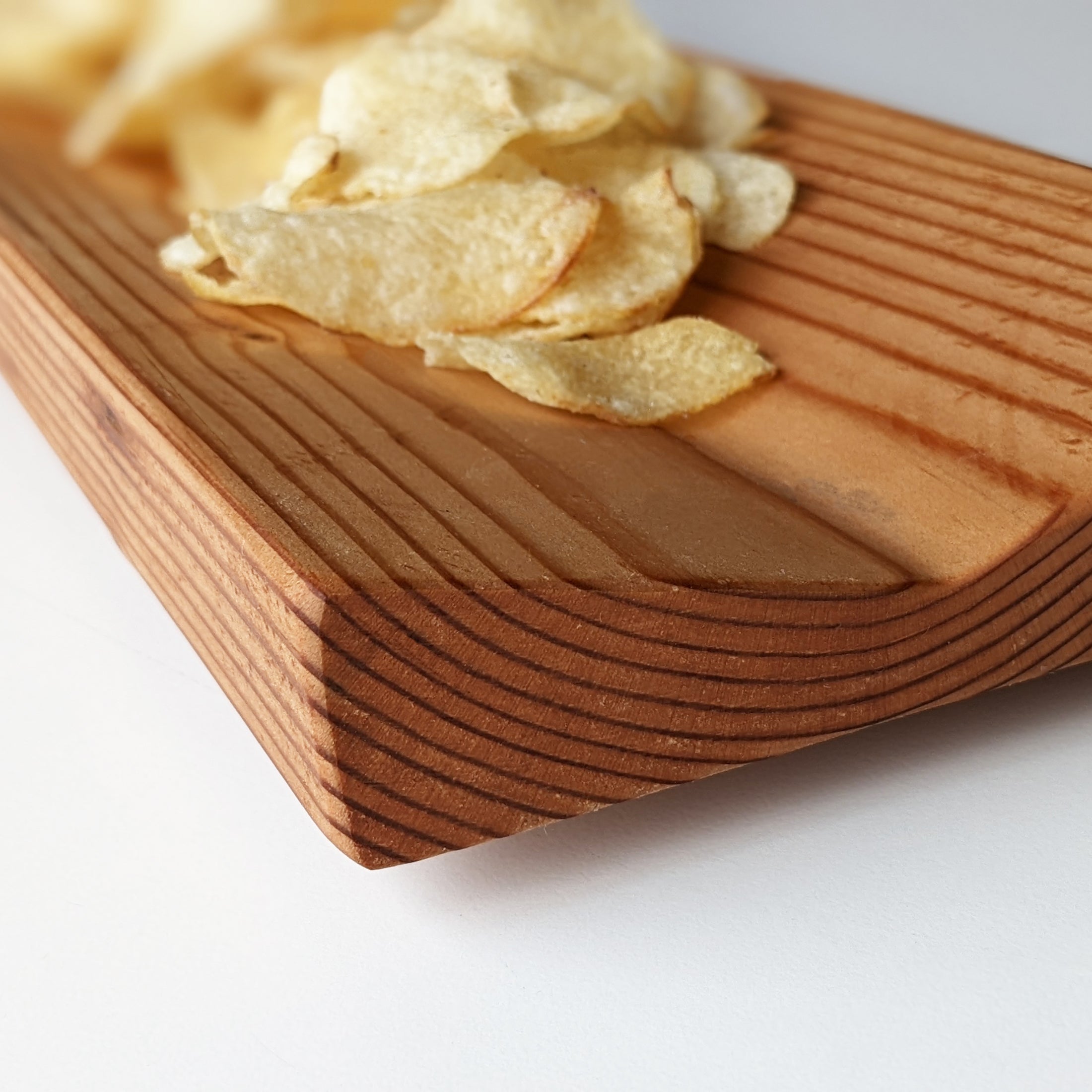 A unique wooden serving tray made from Doug Fir wood, featuring a beeswax finish, perfect for serving snacks during the Super Bowl.