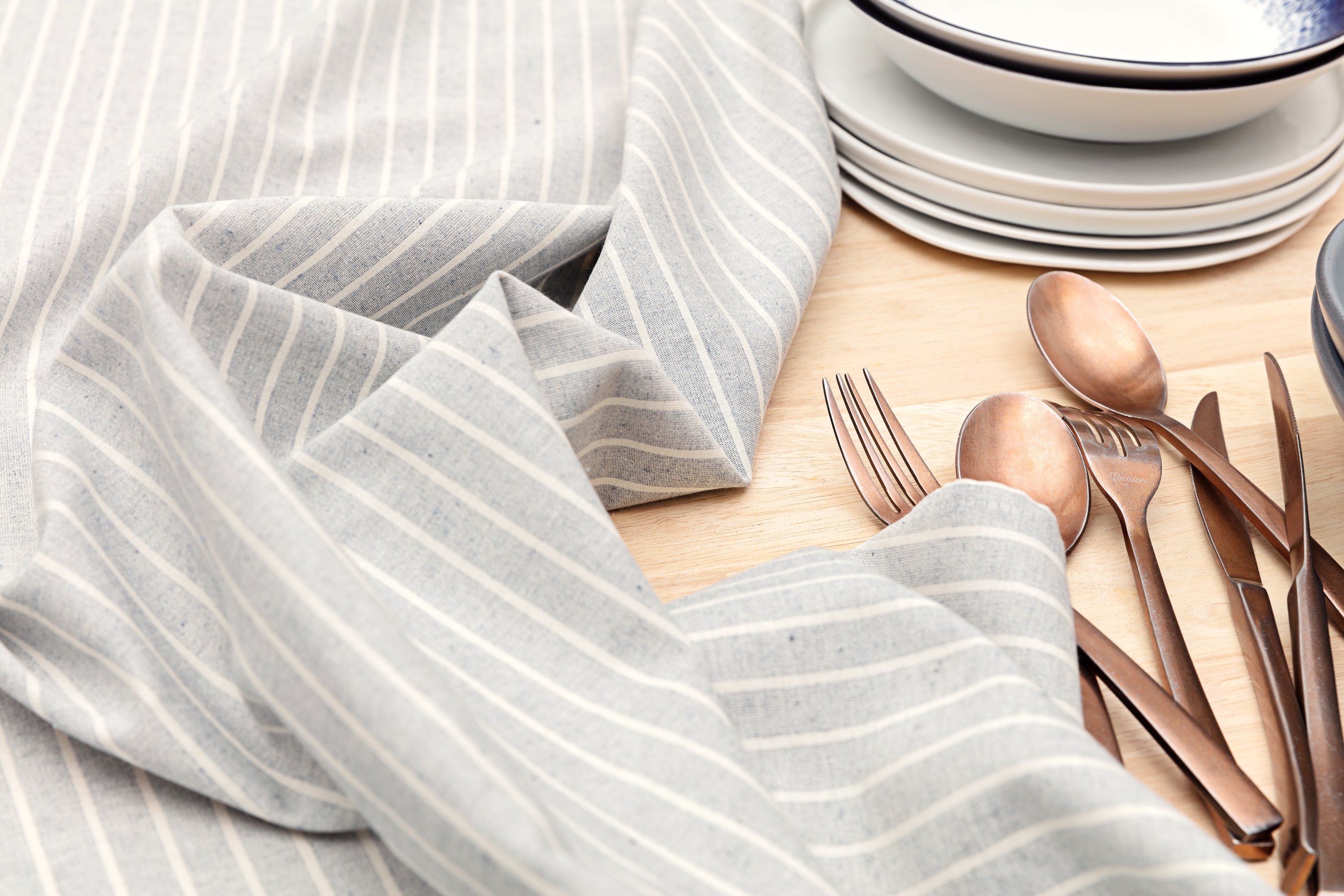 Elegant cotton tablecloth with classic pinstripes in blue-gray and beige colors, perfect for dining occasions.