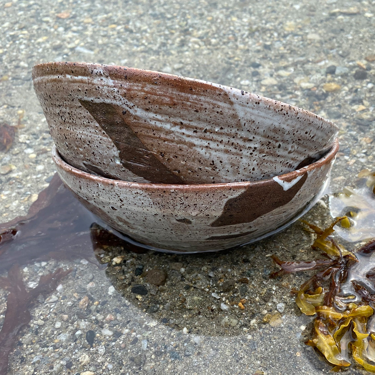 A large TANG ceramic bowl with a unique glaze made from local seaweeds, showcasing its handmade craftsmanship and imperfect design.