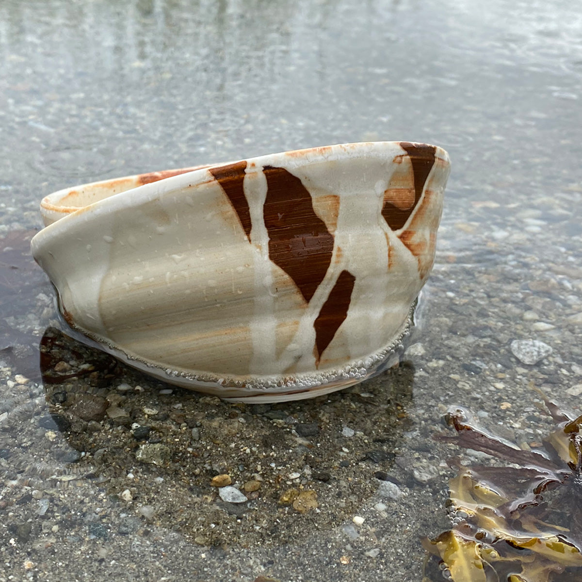 A medium-sized TANG ceramic bowl, handmade in Lofoten, featuring a unique glaze from local seaweeds, showcasing its imperfectly perfect design.