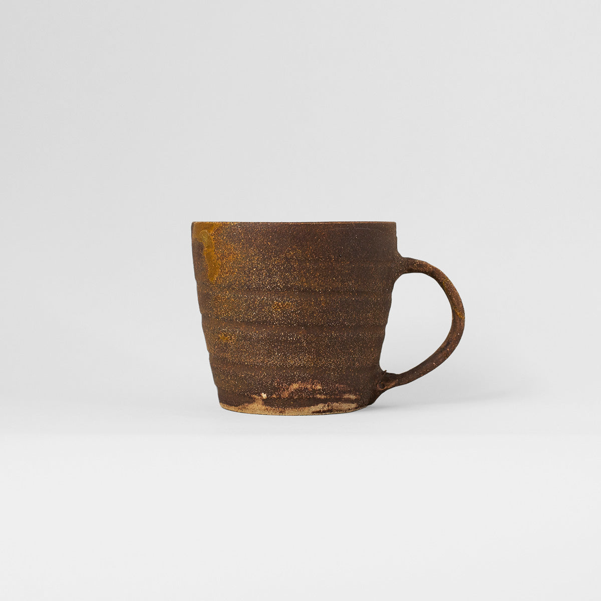 Handmade TANG Ceramic Mug in rich brown color, showcasing unique glaze and artistic design by Gunvor Tangrand.