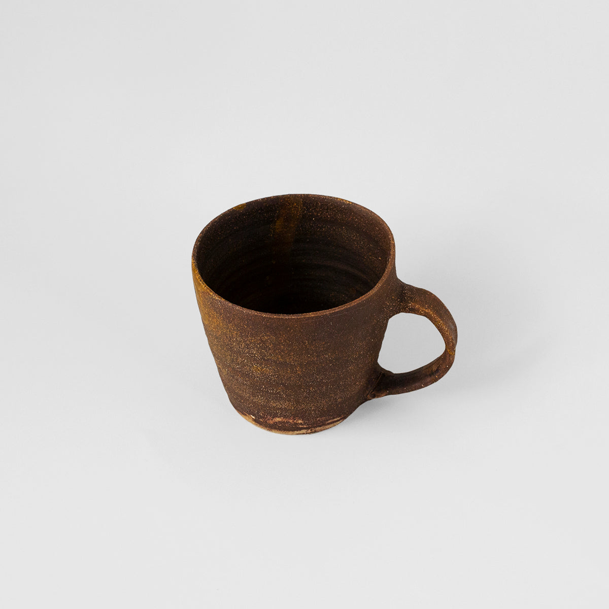 Handmade TANG Ceramic Mug in rich brown color, showcasing unique glaze and artistic design by Gunvor Tangrand.