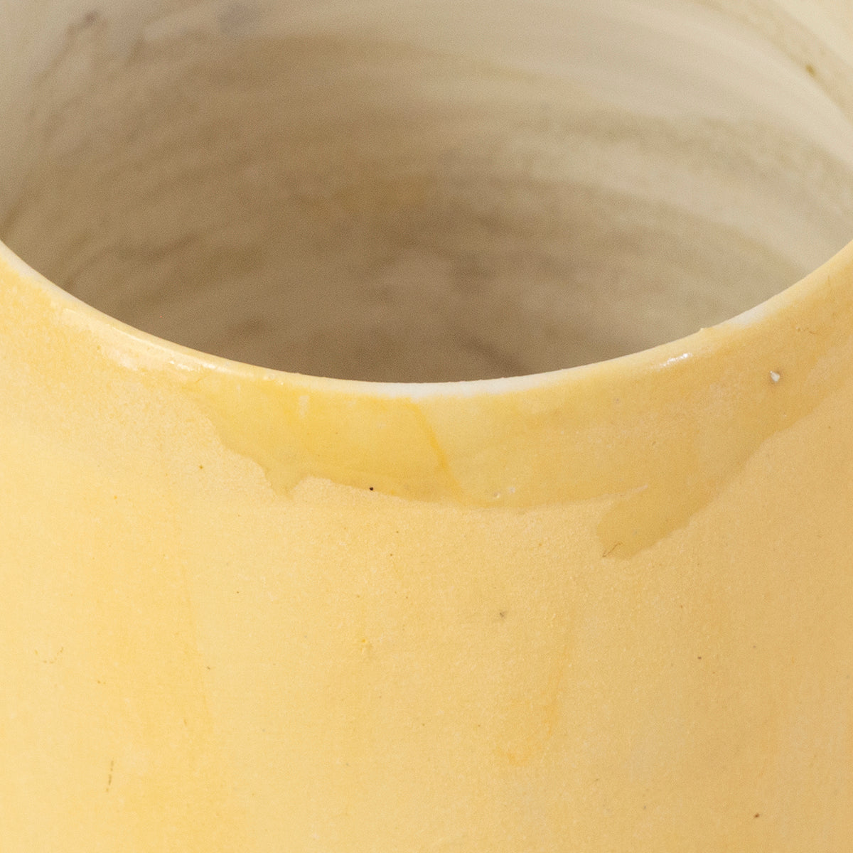 A vibrant yellow handmade ceramic mug by Gunvor Tangrand, showcasing unique glaze and design inspired by Lofoten's nature.