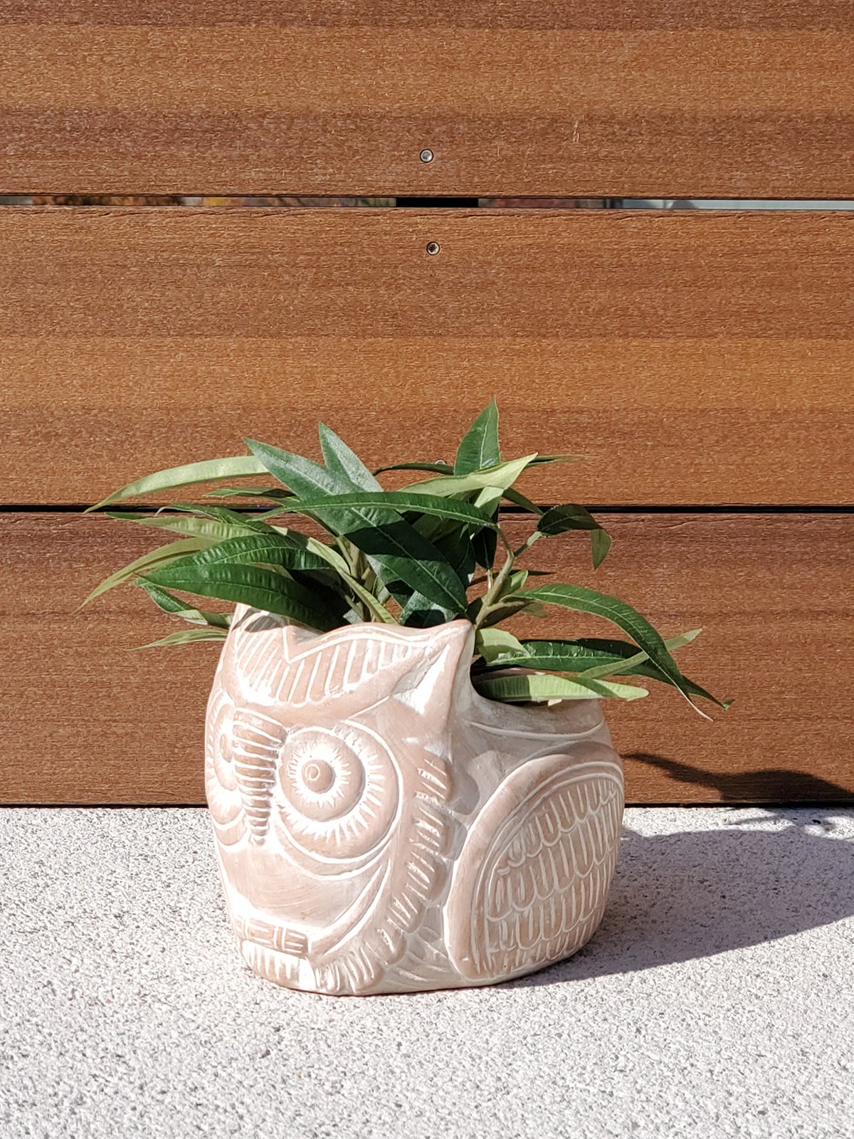 Terracotta pot shaped like a horned owl, perfect for plants and flowers, showcasing unique craftsmanship.