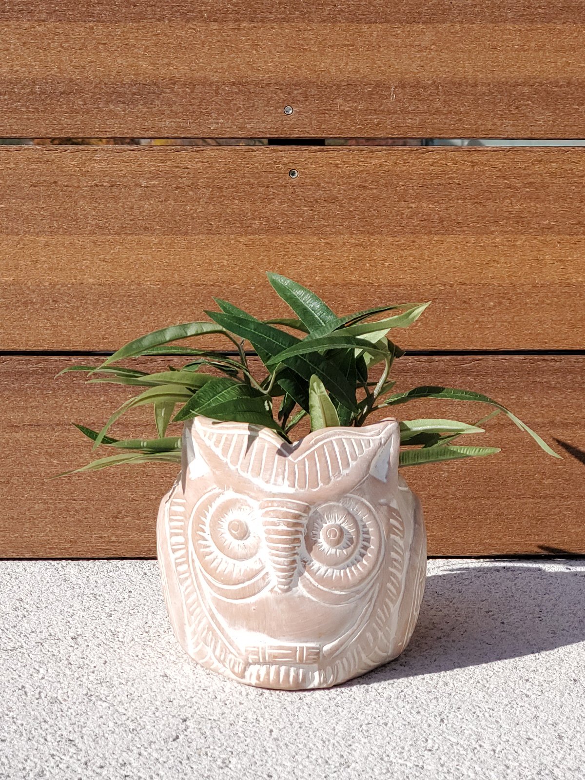 Terracotta pot shaped like a horned owl, perfect for plants and flowers, showcasing unique craftsmanship.