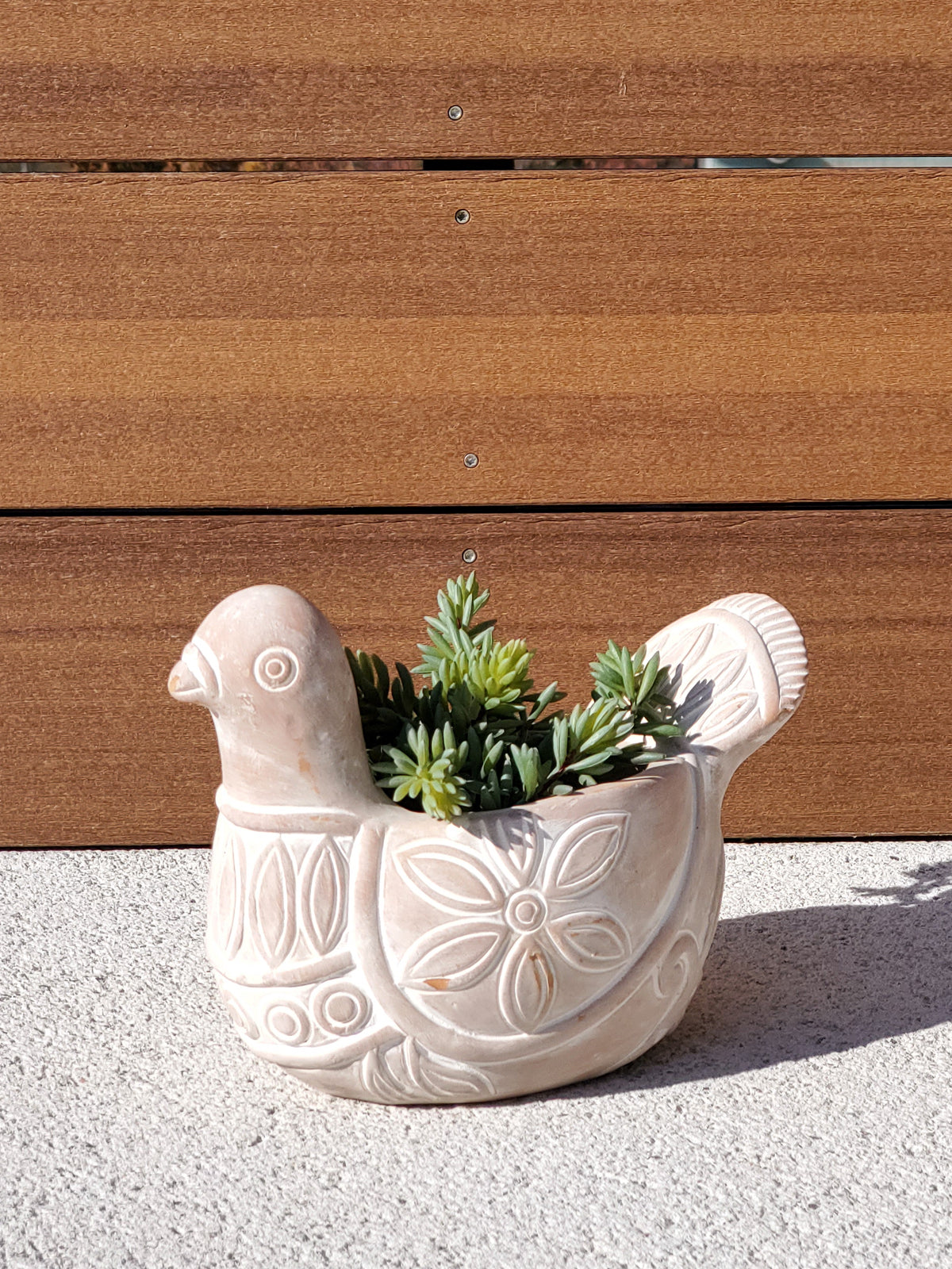 Terracotta pot shaped like a spotted dove, perfect for planting flowers or greenery, showcasing unique craftsmanship.